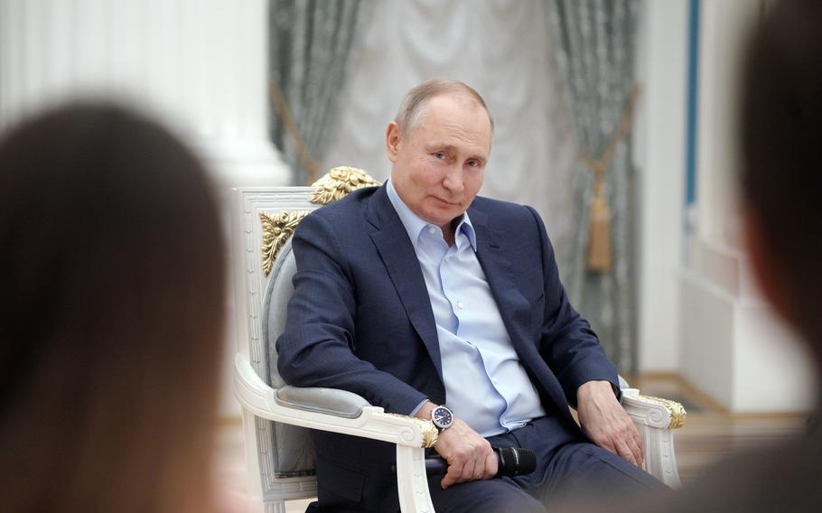 Russian President Vladimir Putin meets with volunteers at the Kremlin in Moscow on March 4, 2021. 