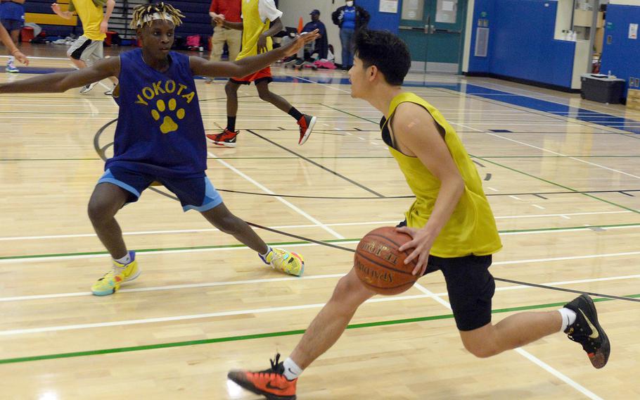 Junior Dylan Tomas, with ball, transferred from Edgren to Yokota; guarding him is freshman Jai Bailey, the third member of that family to play for the Panthers.