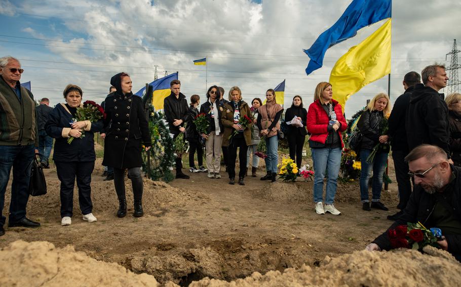 Ukrainian family members and friends attend the funeral of a soldier in the city of Dnipro. He was killed during fighting against invading troops from Russia, Sept. 20, 2022.