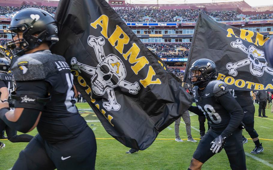 Players carry flags that say Army Football.