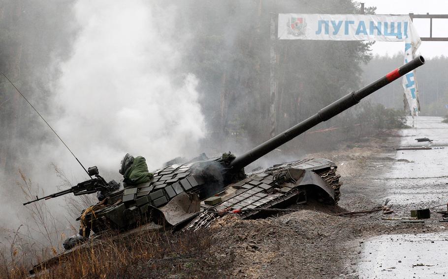 Smoke rises from a Russian tank destroyed by the Ukrainian forces on the side of a road in Lugansk region on Feb. 26, 2022. 