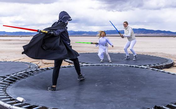 People battle with light sabers on trampolines at OutpostX in Beryl, Utah. 