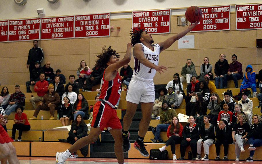 Vilseck's Brandon Goins goes up for a layup on a fast break during a Dec. 2, 2023, game at Kaiserslautern High School in Kaiserslautern, Germany. Defending is Raider Rueben Todman.