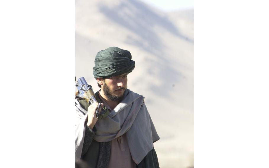 A Taliban fighter prepares to surrender to Northern Alliance forces Sunday, Nov. 25, 2001, after a bitter battle that lasted several days outside of the capital city of Kabul.