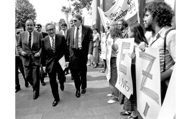 Worms, Germany, June 12, 1983: Former Secretary of State Henry Kissinger walks past a line of protesters on his way to speak at a German-American tricentennial ceremony. At left is German Foreign Minister Hans-Dietrich Genscher. The protesters are holding letters forming the word "freeze," in connection with nuclear disarmament.

Looking for Stars and Stripes’ historic coverage? Subscribe to Stars and Stripes’ historic newspaper archive! We have digitized our 1948-1999 European and Pacific editions, as well as several of our WWII editions and made them available online through https://starsandstripes.newspaperarchive.com/

META TAGS: U.S. foreign policy; Kissinger; Jewish American Heritage Month; anti-nuclear protest; stop the bomb