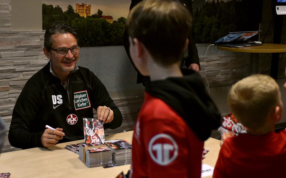 1. FC Kaiserslautern manager Dirk Schuster signs cards during an event on March 23, 2023 at the community center on Ramstein Air Base, Germany.