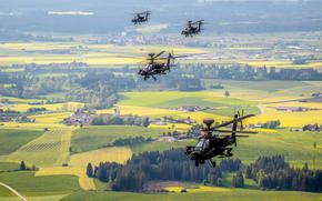 A formation of AH-64 Apache attack helicopters flies over Germany in 2020. Defense Secretary Pete Hegseth has directed the Army to reduce and restructure manned attack helicopter formations and augment them with inexpensive drone swarms, among other measures outlined in a memo issued April 30, 2025. 