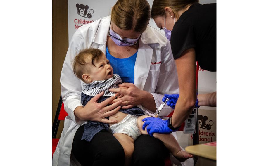 Physician Sarah Schaffer Deroo calms her 7 month-old-son, Hewitt, as he receives a coronavirus vaccine in D.C. 