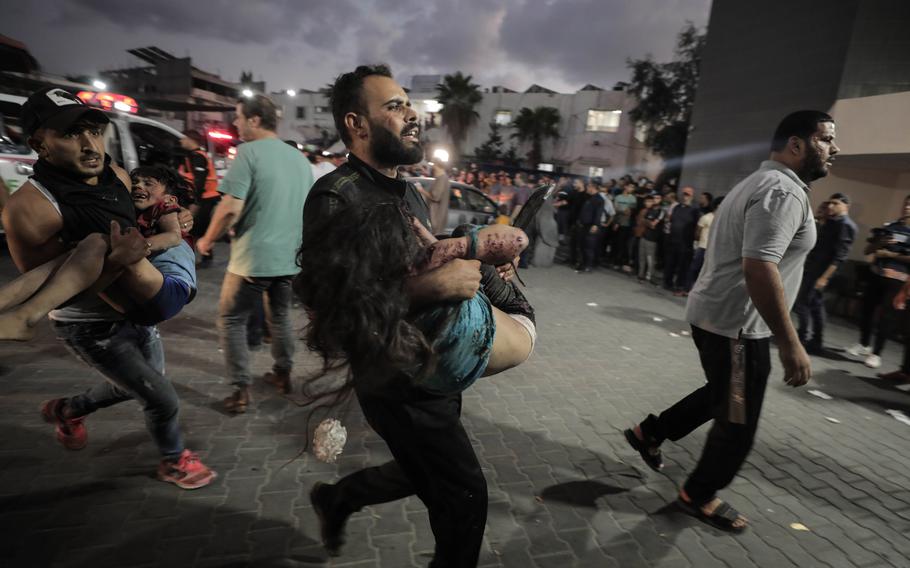 Two injured children are carried toward a medical complex Wednesday after an Israeli strike on a neighborhood in the Gaza Strip.