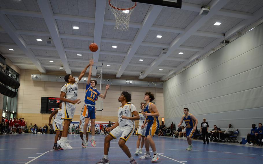 Wiesbaden’s Gavin DeLuca shoots the ball as Stuttgart’s Alex Guthrie tries to block his shot during the Division I boys basketball championships at Ramstein Air Base in Germany on Feb. 16, 2023. 