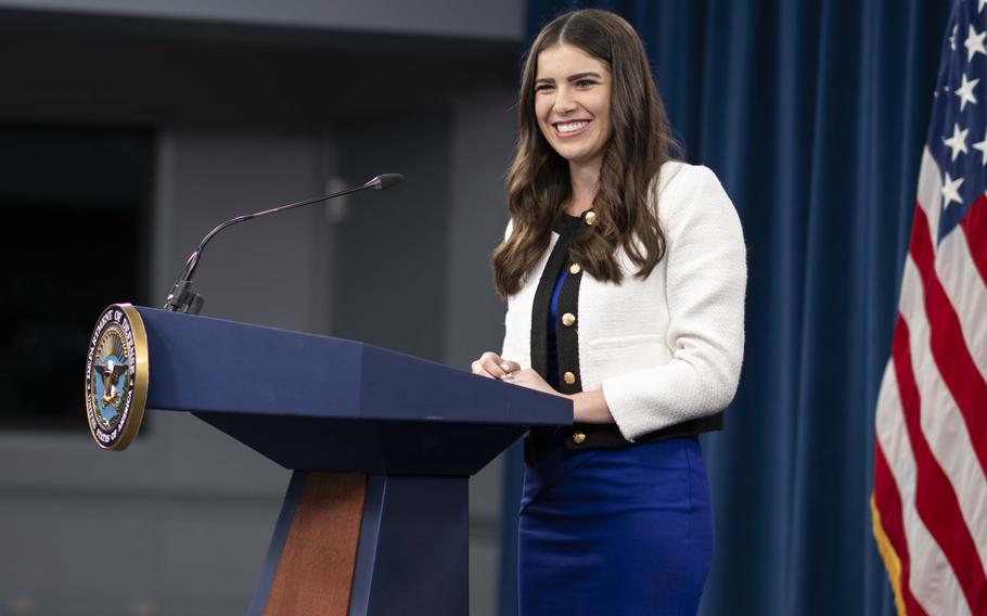 Kingsley Wilson smiling and standing at a podium with an American flag behind her.