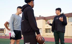 Dartmouth University running back Noah Roper talks football with players from Yokota High School during a drill session at Yokota Air Base, Japan, Jan. 19, 2024. 