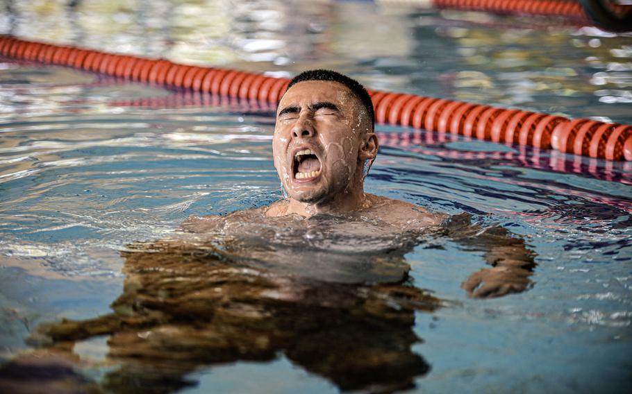 U.S. Space Force Tech. Sgt. Mark Fitzgerald, an operations flight chief with the 53rd Satellite Operations Squadron in Landstuhl, Germany, removes his uniform top while treading water during the swim portion of the German Armed Forces Badge for Military Proficiency at Ramstein Air Base, Germany, April 22, 2024.