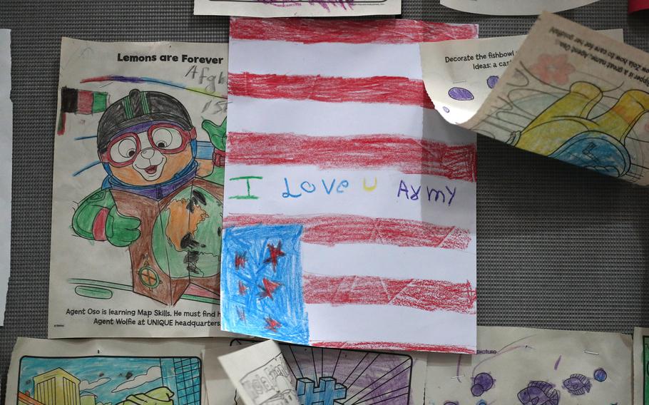 Children's drawings line the walls in the intake facility where evacuees go through processing when they arrive at Camp Atterbury for Operation Allies Welcome. 