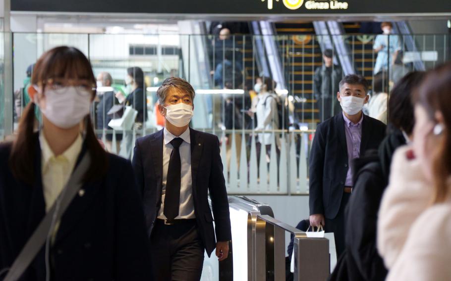 Commuters wear masks at Shibuya Station in Tokyo, Friday, March 10, 2023. 