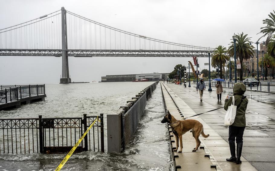 Pedestrians walk along the Embarcadero in San Francisco.