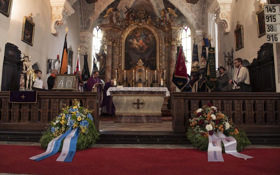 Two wreaths sit at the base of an altar inside a church.
