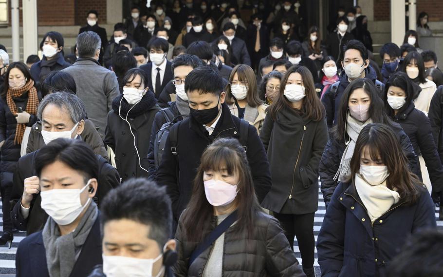 Commuters wear masks outside Tokyo Station in Tokyo Friday, Jan. 20, 2023. Japan's Prime Minister Fumio Kishida on Friday announced plans to start preparations for downgrading legal status of COVID-19 to an equivalent of seasonal influenza in the spring, a move that would further relax mask wearing and other preventive measures as the country seeks an exit plan.
