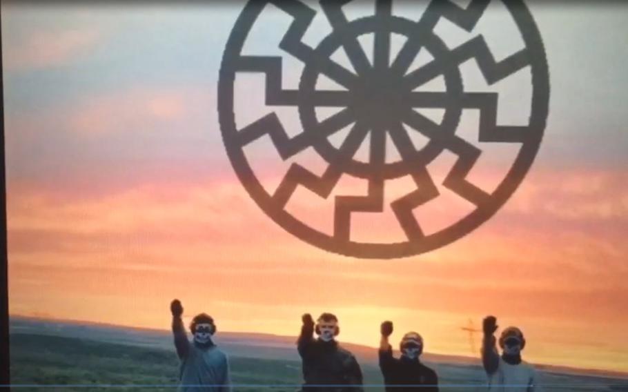 A screenshot from a training video shows four of the five men who federal prosecutors say plotted an attack on the U.S. power grid performing Nazi salutes. Another frame of the video displays the phrase “Come home white man.” 