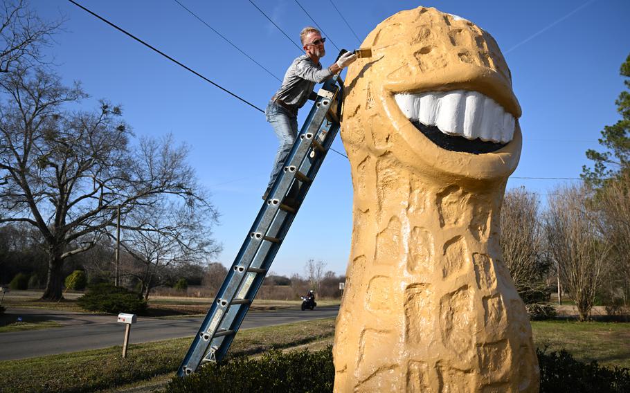 Michael Dominick paints the Smiling Peanut on Sunday in Plains, Ga. The peanut was presented to Jimmy Carter during a campaign event in Evansville, Ind., in 1976. 