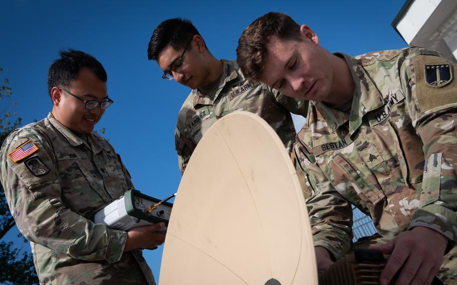 From right, Army Sgt. Justin Sestan, Staff Sgt. Karlos Vasquez and Spc. Jason Xia work with a satellite and monitoring device during exercise Arcane Thunder in Ustka, Poland, on Sept. 4, 2023. 