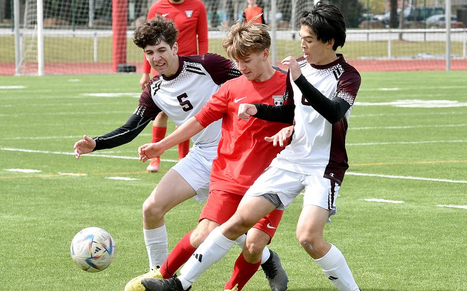 Vilseck's John Allen Koyama, right, pokes the ball away from Kaiserslautern's Nikolai Engeman, center, during a Saturday afternoon match at Kaiserslautern High School in Kaiserslautern, Germany. Also defending for Vilseck is Gabe Darnell.