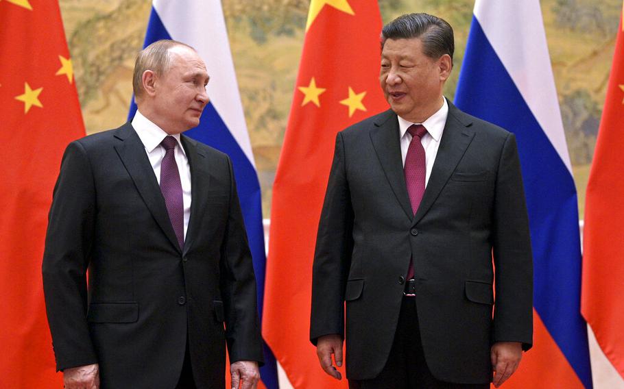 Chinese President Xi Jinping, right, and Russian President Vladimir Putin talk to each other during their meeting in Beijing, China, on Feb. 4, 2022. 