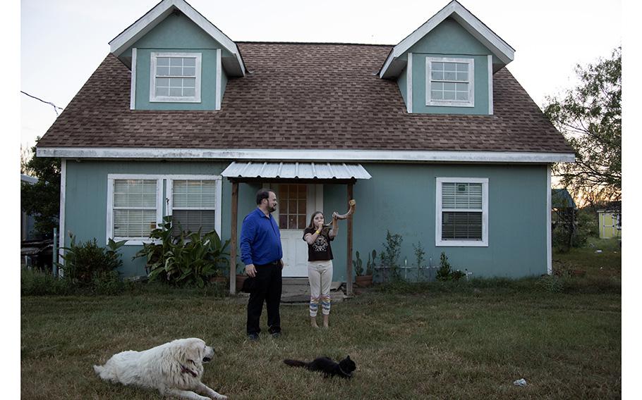 John Holcombe and his daughter, Evelyn, outside their home with their dog, Zeke, and cat, Prr Prr. Zeke was Crystal Holcombe’s dog and Prr Prr was Megan Hill’s cat. Crystal, Evelyn’s mother, and Evelyn’s 9-year-old sister, Megan, were killed in the shooting at their church in 2017. 