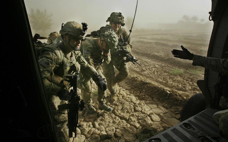 Spc Mitchel Holland, of 4th Squadron, 4th Cavalry Regiment, 1st Heavy Combat Brigade, 1st Infantry Division is helped on to a medevac helicopter after being injured just east of Sangasar on June, 15, 2011, in Kandahar province Afghanistan. 