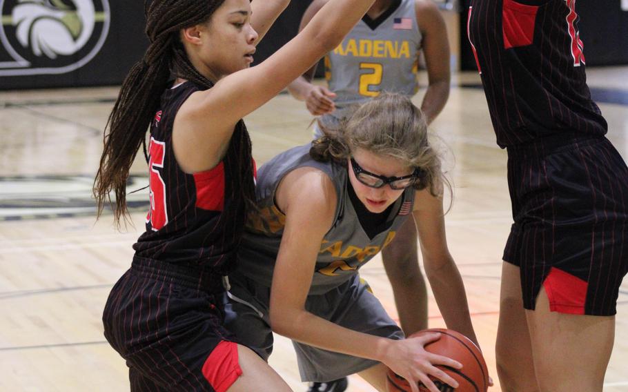 Kadena's Marina Sawyer tries to play keepaway against Nile C. Kinnick during Tuesday's Girls Division I round-robin game, won by the Panthers 32-24.