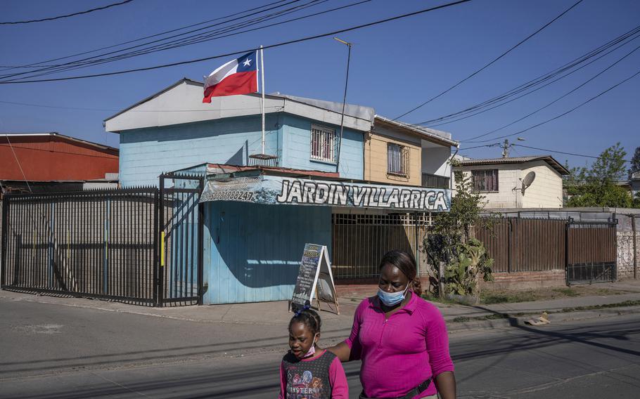 A Haitian woman and girl walk down the street in Quilicura, a neighborhood in Santiago, Chile, known as Little Haiti.