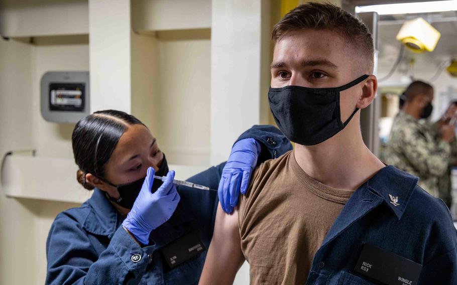 Seaman Jlyn Bautista administers a COVID-19 vaccine to Petty Officer 3rd Class Nicholas Wingle aboard the amphibious transport dock ship USS Arlington, April 23, 2021. 