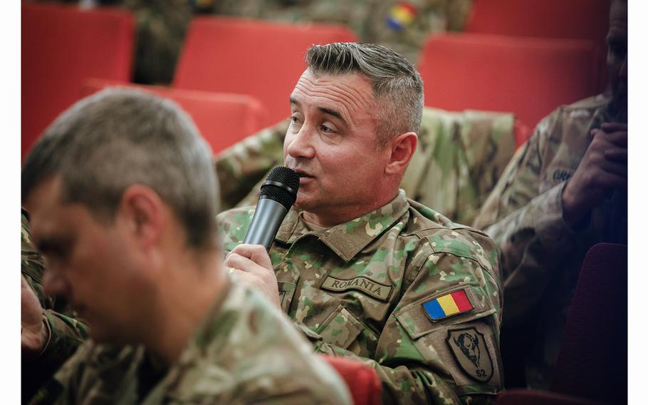 Romanian armed forces officer Florin Cotet asks questions at the High Mobility Artillery Rocket System summit in Bucharest, Romania, on Dec. 7, 2023. The gathering was a collaboration between U.S. Army V Corps soldiers and service members of NATO allies.