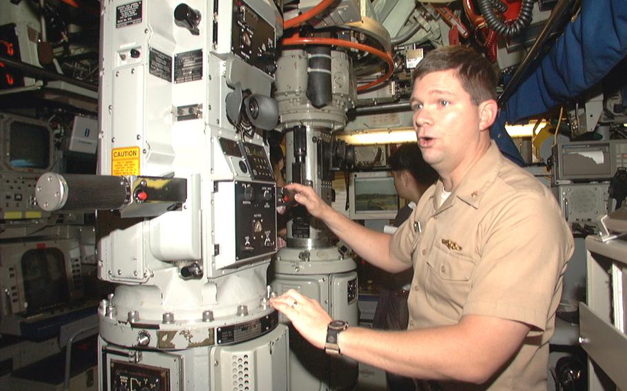 Navy Lt. Cmdr. Eric Holloway, executive officer for USS Bremerton, explains how the submarine periscope operates. USS Bremerton stopped at White Beach Naval Facility during Annual Exercise 2001, a bilateral training exercise with the Japanese Maritime Self-Defense Force.  