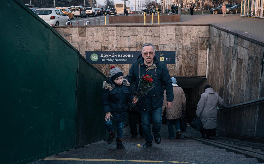 Hrysha walks with his grandfather after buying flowers for his grandmother on international women's day.
