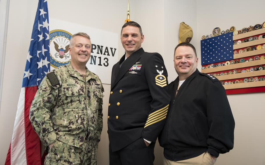 Vice Adm. Rick Cheeseman, right, and Rear Adm. Jim Waters, left, present the new Robotics Warfare Specialist (RW) rating insignia to Master Chief Robotics Warfare Specialist Christopher Rambert at Naval Support Facility Arlington, Va., Tuesday, Feb. 27, 2024. 