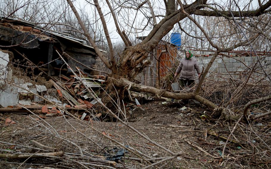 Liudmyla Kulik stands near her damaged hen house and a fallen tree on Dec. 14, 2021. The damage was caused by shelling in October in Hranitne, Ukraine. 
