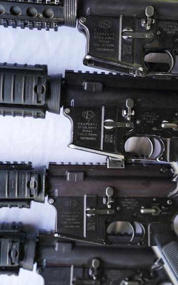 A close-up of some M-16 rifles that say property of the U.S. government. 