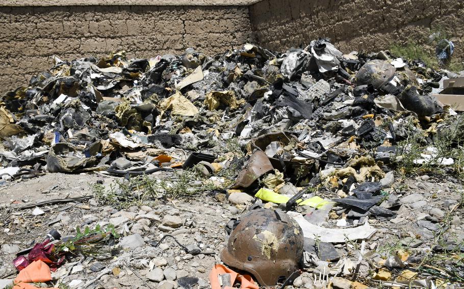 A helmet from Bagram Airfield, Afghanistan, sits in front of a pile of ruined helmets at a trash yard outside the base June 5, 2021. Departing U.S. and NATO troops have crushed most of their discarded trash.