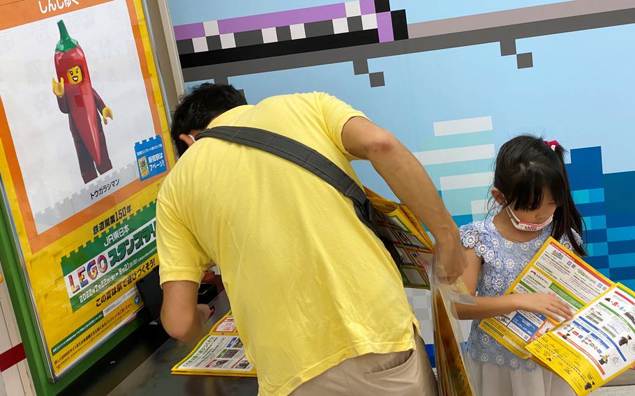 A family collects special Lego stamps at Shinjuku Station in central Tokyo, Saturday, July 30, 2022. 