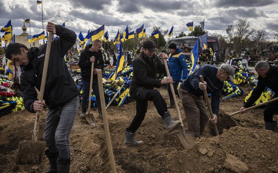 The graves of two Ukrainian soldiers, Dmytro Medvid, 33, and Oleksandr Ulanovskyy, 37, are covered during thier funeral on the outskirts of Kherson in mid-November.