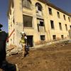 LOS ANGELES, CA - JUNE 23, 2022 - - Construction workers walk past Building 207 that is being refurbished as housing for veterans on the Veteran Affairs West LA campus in Los Angeles on June 23, 2022. This is the Collective's first project, a 60-unit building for senior veterans and their families and is scheduled to open this fall. Along with U.S. VETS, the Collective is made up of Century Housing, a nonprofit that builds and finances affordable housing, and Thomas Saffran and Associates, a Brentwood-based for-profit affordable housing developer. The master plan calls for 14 buildings to be brought up to current standards but preserved in their original form with another 14 built from the ground up. (Genaro Molina / Los Angeles Times)