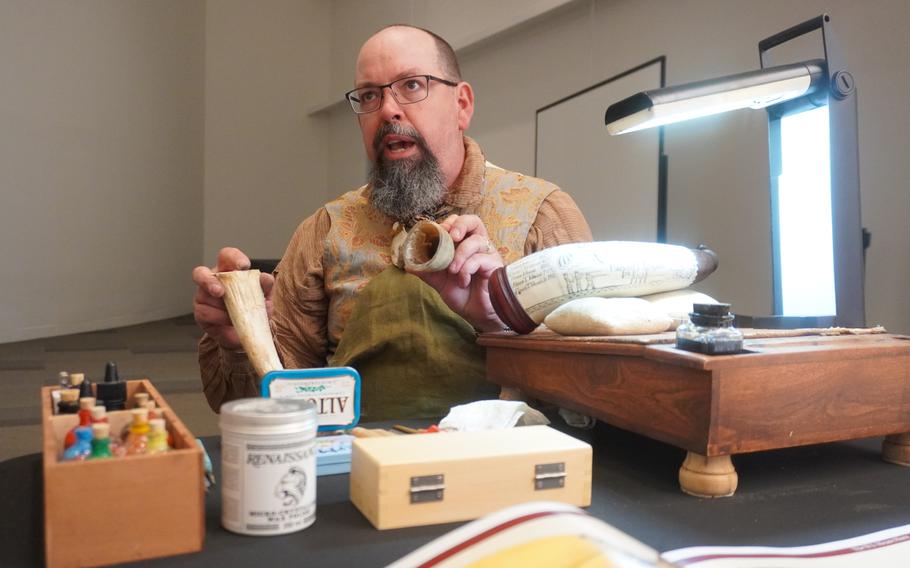 A man holds up a powder horn