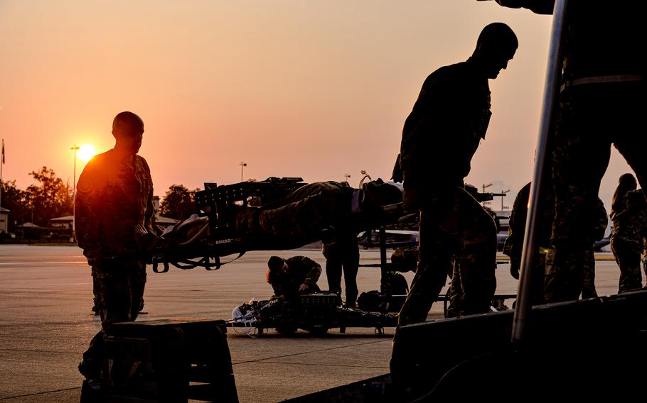 Members of the Air Force's 86th Medical Squadron board a C-130 Hercules with a medical training mannequin June 6, 2023, at Ramstein Air Base, Germany, as part of Saber Guardian 23. The exercise took medical evacuation teams to Romania and back to Germany on a simulated patient care flight.