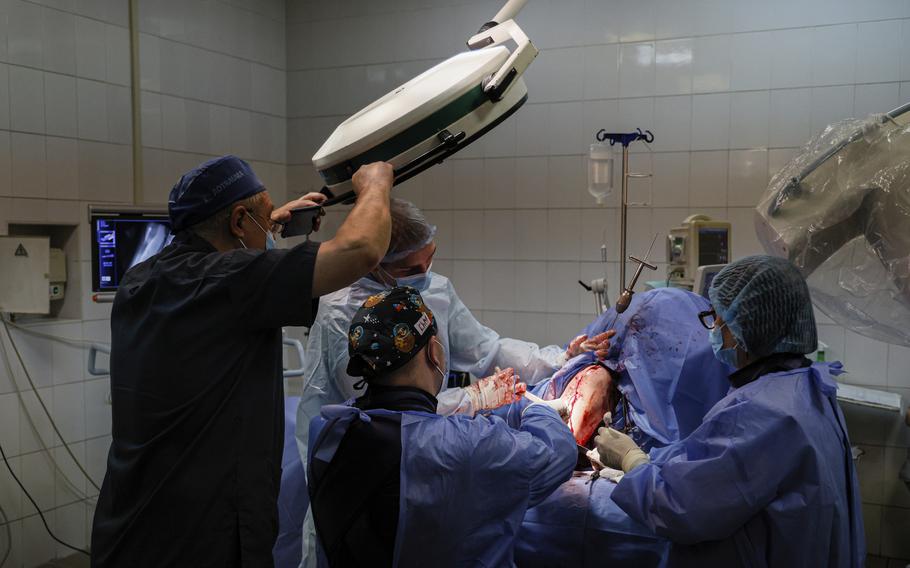 Petro Nikitin, left, takes part in a surgery operation of a Ukrainian serviceman at the military hospital in Kyiv, Ukraine, on Thursday, May 5, 2023. As the lead trauma surgeon at a military hospital in the Ukrainian capital, he's been confronted with the realities of the bloody conflict since day one of the Russian invasion some 14 months ago.