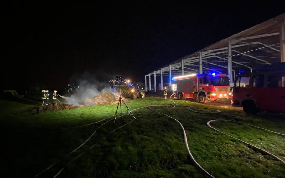 German and American firefighters battle flames at an agricultural storage area in Delkenheim, Germany, early Tuesday, Dec. 28, 2021. U.S. Army firefighters from Wiesbaden helped extinguish the fire, which broke out in a large manure heap. 