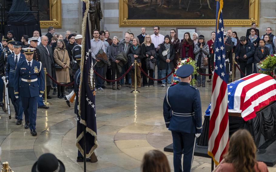 Mourners watch the changing of the honor guard at the Capitol Rotunda.