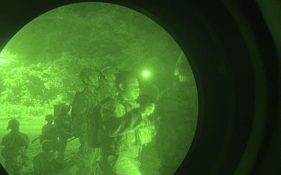 American and Korean soldiers walk together in this picture taken through a night vision lens.