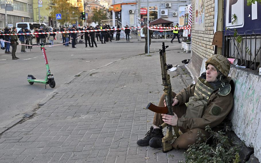 A Ukrainian serviceman watches the sky during a drone attack in Kyiv on Oct. 17, 2022, amid the Russian invasion of Ukraine. 