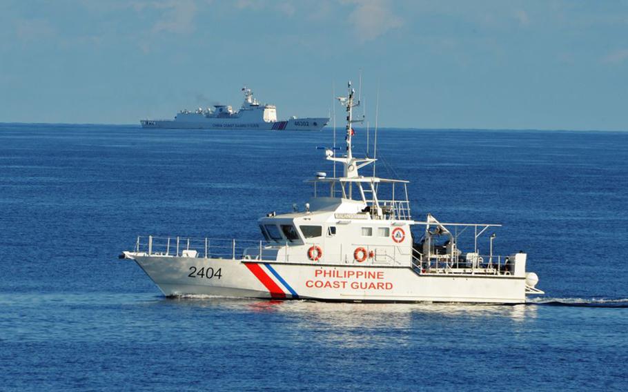 This photo taken on May 14, 2019, a Philippine coast guard ship (right) sails past a Chinese coast guard ship during a joint search and rescue exercise between Philippine and US coast guards near Scarborough shoal, in the South China Sea, on May 14, 2019. 